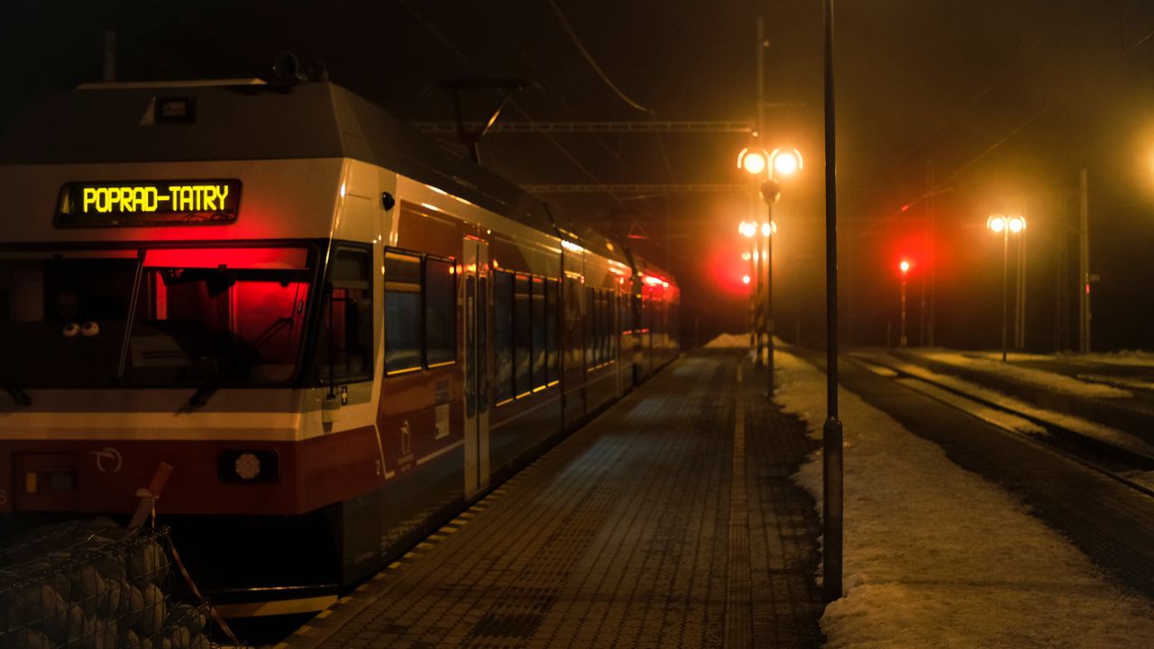 Peron małej górskiej stacji kolejowej o zmierzchu z mgłą