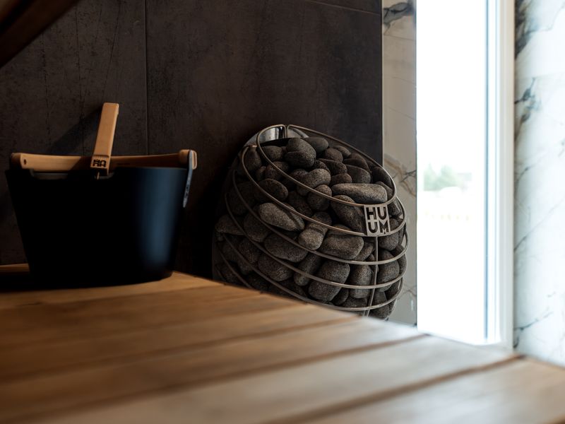 Strefa SPA w kompleksie hotelowym w górach: sauna fińska i leżaki z widokiem na ogród