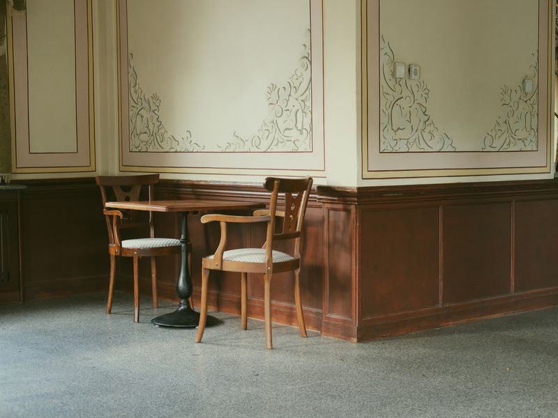 Wnętrze kameralnego hotelu w górach — recepcja z ciemnego drewna z widokiem na las